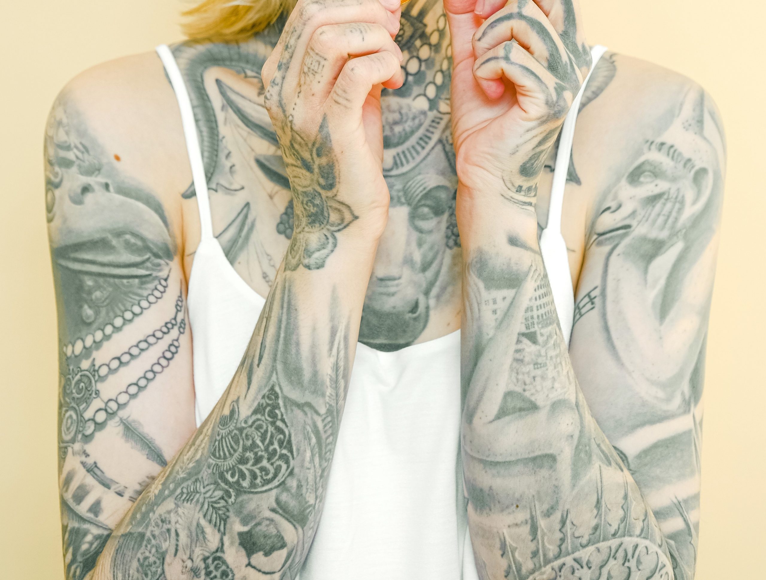 Tattooed girl's arms with custom black and grey realistic sleeves